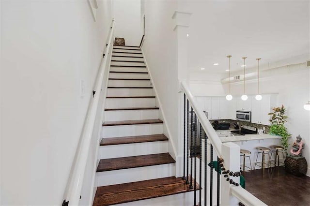 staircase featuring ornamental molding