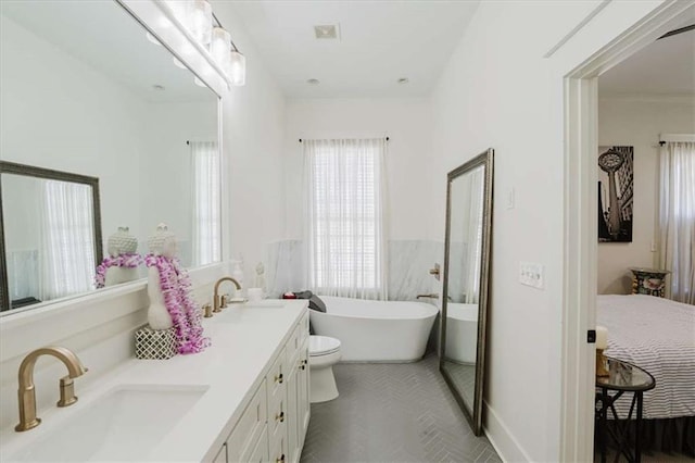 bathroom featuring toilet, a bathing tub, and vanity