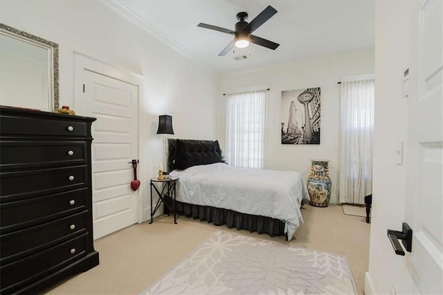 carpeted bedroom with ceiling fan and ornamental molding