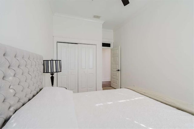 unfurnished bedroom featuring ceiling fan, a closet, and crown molding