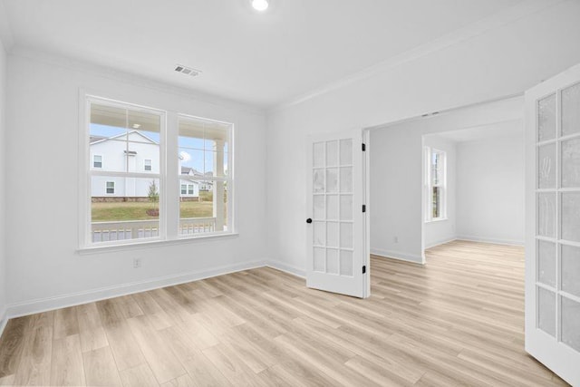 unfurnished room featuring french doors, ornamental molding, and light hardwood / wood-style flooring