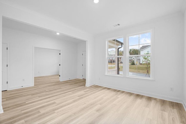 unfurnished room with ornamental molding and light hardwood / wood-style flooring