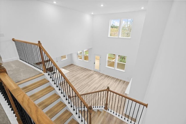 stairs with hardwood / wood-style floors and a wealth of natural light