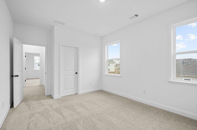 unfurnished bedroom featuring light carpet