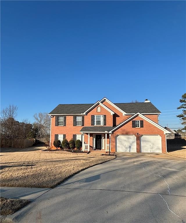 view of front of property featuring a garage, concrete driveway, and brick siding