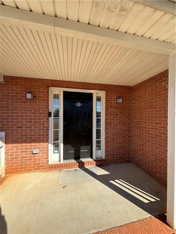 doorway to property featuring brick siding