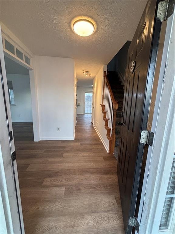 interior space with baseboards, dark wood finished floors, stairway, and a textured ceiling