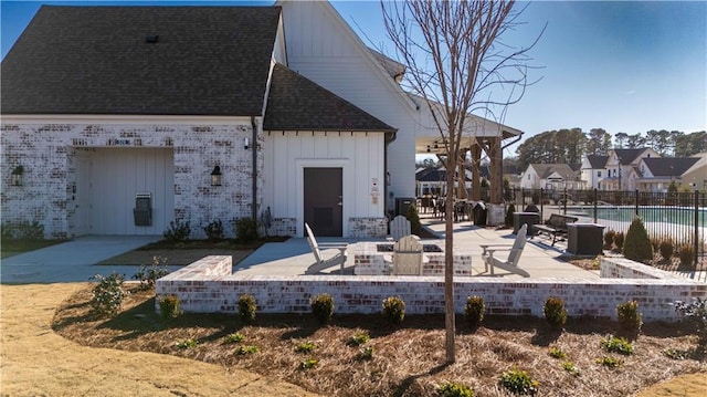 551 Pearl St, Cumming, GA 30040 - rear view of property with board and batten siding, a patio, and a shingled roof