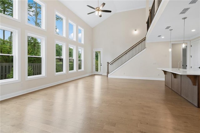 551 Pearl St, Cumming, GA 30040 - unfurnished living room featuring a ceiling fan, light wood-style floors, high vaulted ceiling, and stairway