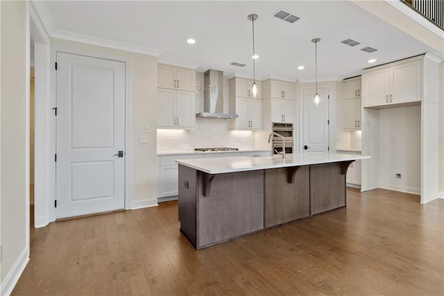 551 Pearl St, Cumming, GA 30040 - kitchen with wall chimney exhaust hood, stainless steel appliances, dark wood-style flooring, decorative backsplash, and light countertops