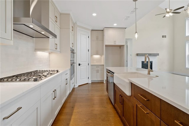 551 Pearl St, Cumming, GA 30040 - kitchen featuring stainless steel appliances, wall chimney range hood, ceiling fan, pendant lighting, and light stone countertops