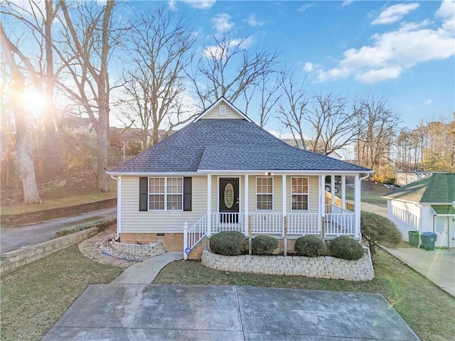 bungalow-style house featuring covered porch and a front yard