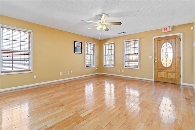 foyer entrance with ceiling fan, a textured ceiling, and light wood-type flooring