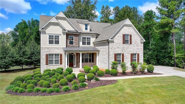 view of front of property with driveway, stone siding, covered porch, a front yard, and brick siding