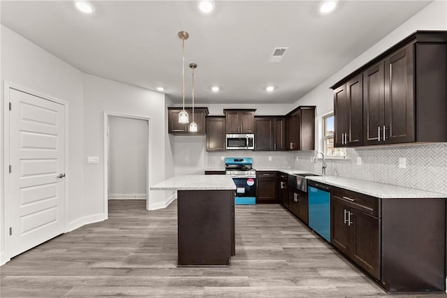 kitchen featuring stainless steel appliances, light wood-style floors, a sink, and dark brown cabinets