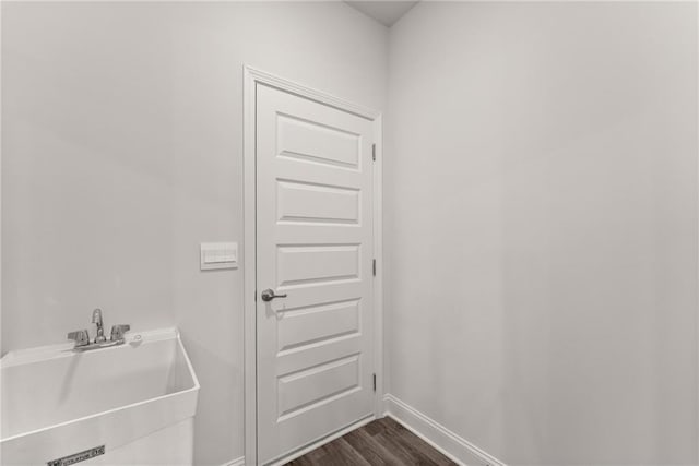 bathroom featuring a sink, baseboards, and wood finished floors