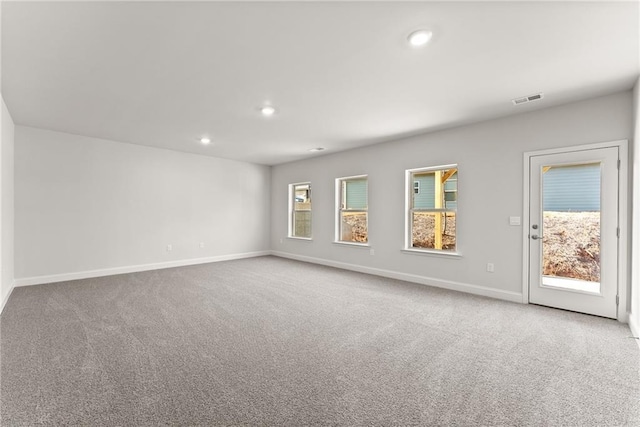 carpeted empty room featuring recessed lighting, visible vents, and baseboards