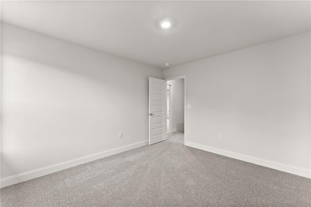spare room featuring carpet flooring and baseboards