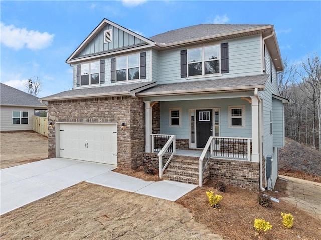 view of front of property featuring brick siding, covered porch, concrete driveway, board and batten siding, and a garage