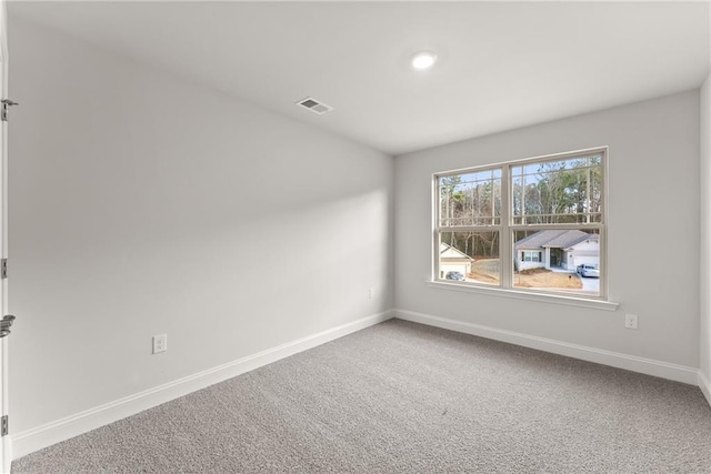 unfurnished room featuring carpet, visible vents, and baseboards