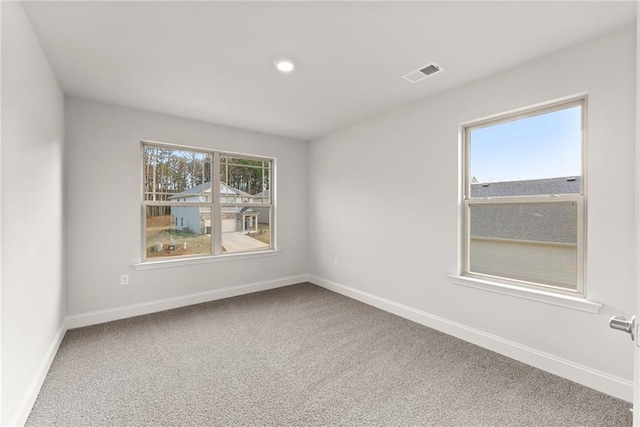 carpeted spare room featuring recessed lighting, visible vents, and baseboards