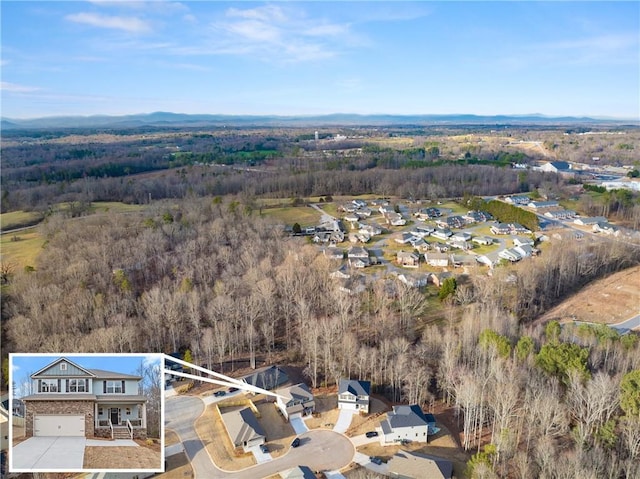 drone / aerial view with a wooded view