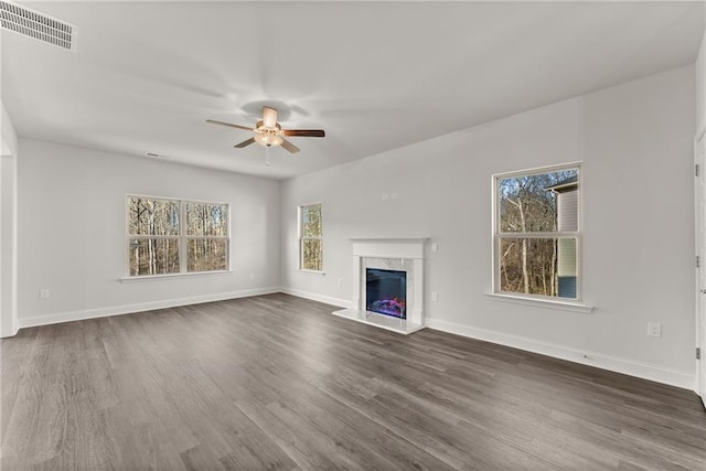 unfurnished living room with dark wood-style flooring, visible vents, a fireplace, and baseboards