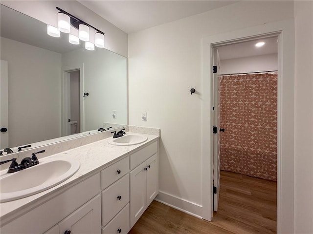 201 Advent Dr, Winder, GA 30680 - bathroom featuring wood finished floors, double vanity, and baseboards