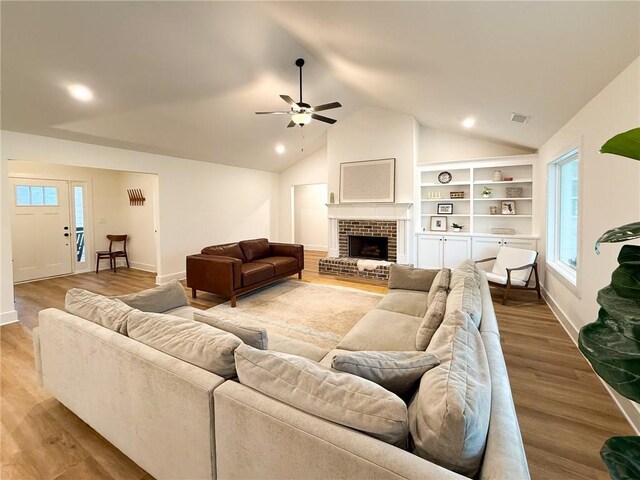 201 Advent Dr, Winder, GA 30680 - living area featuring a ceiling fan, lofted ceiling, wood finished floors, a brick fireplace, and baseboards