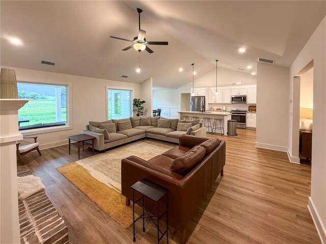 201 Advent Dr, Winder, GA 30680 - living room featuring vaulted ceiling, baseboards, ceiling fan, and light wood-style floors