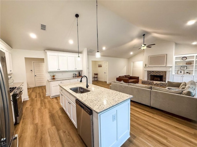 201 Advent Dr, Winder, GA 30680 - kitchen with appliances with stainless steel finishes, a sink, a ceiling fan, vaulted ceiling, and white cabinetry