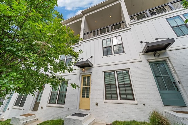 1227 Cushenberry Ln, Atlanta, GA 30318 - rear view of house with board and batten siding, entry steps, and brick siding