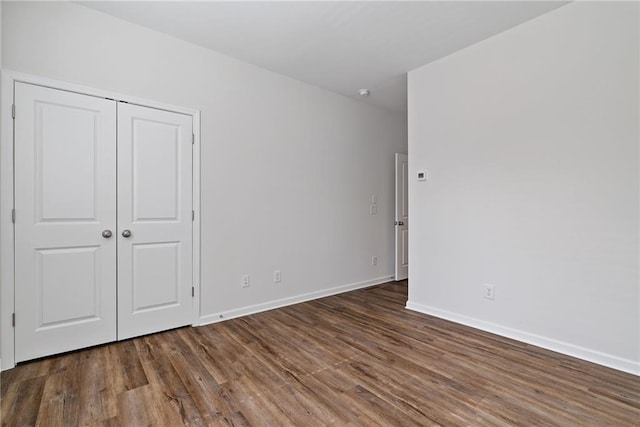 1227 Cushenberry Ln, Atlanta, GA 30318 - unfurnished bedroom with wood finished floors, baseboards, and a closet