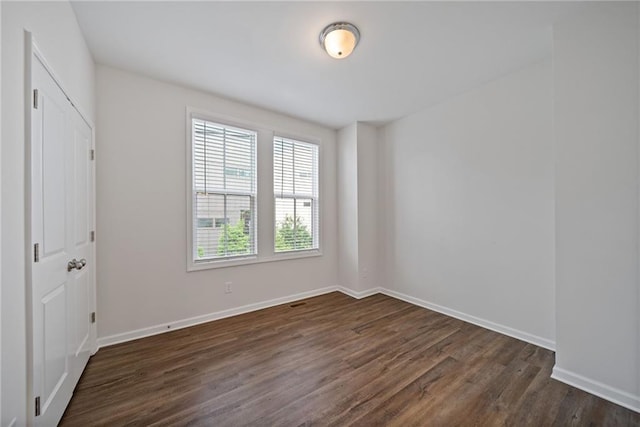 1227 Cushenberry Ln, Atlanta, GA 30318 - unfurnished bedroom with multiple windows, dark wood-style floors, and baseboards