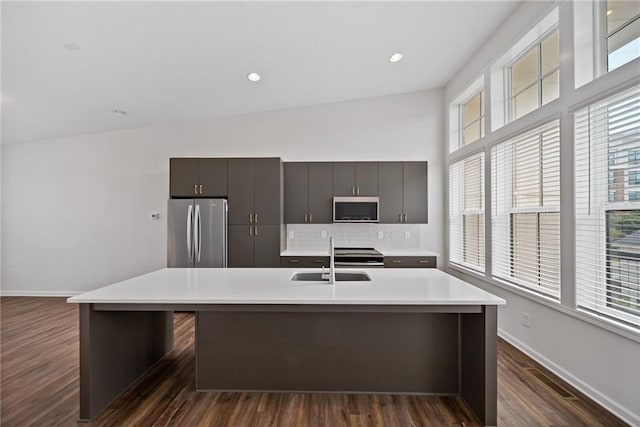 1227 Cushenberry Ln, Atlanta, GA 30318 - kitchen featuring appliances with stainless steel finishes, a sink, light countertops, a kitchen island with sink, and dark wood-style floors