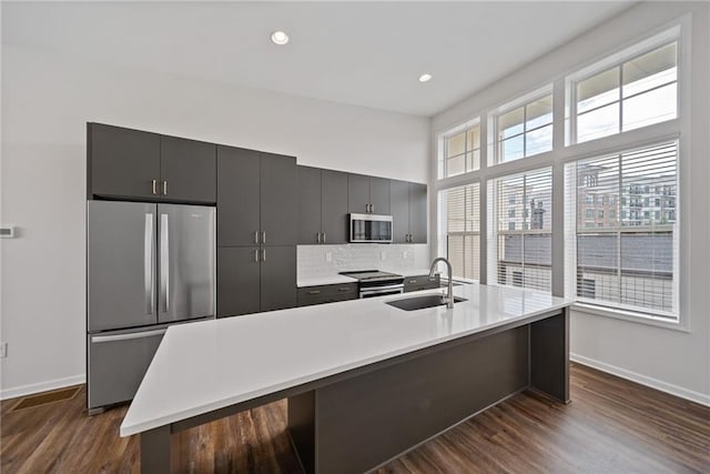 1227 Cushenberry Ln, Atlanta, GA 30318 - kitchen featuring appliances with stainless steel finishes, a sink, baseboards, dark wood-type flooring, and light countertops