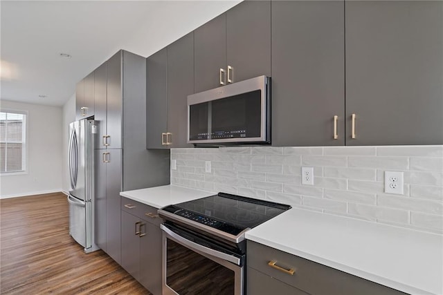 1227 Cushenberry Ln, Atlanta, GA 30318 - kitchen with appliances with stainless steel finishes, light wood-style flooring, decorative backsplash, and light countertops