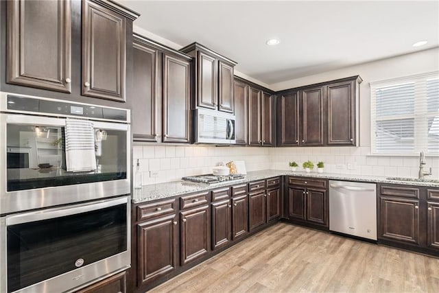 kitchen featuring appliances with stainless steel finishes, sink, and dark brown cabinetry