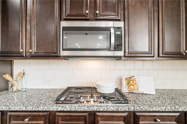 kitchen with appliances with stainless steel finishes and dark brown cabinets