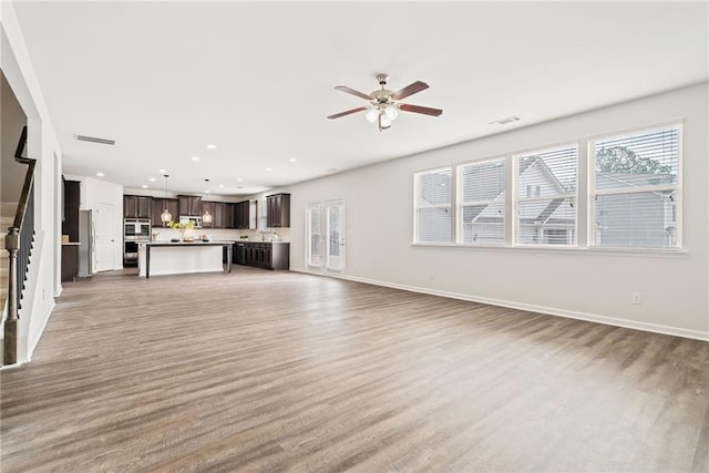 unfurnished living room featuring hardwood / wood-style floors and ceiling fan