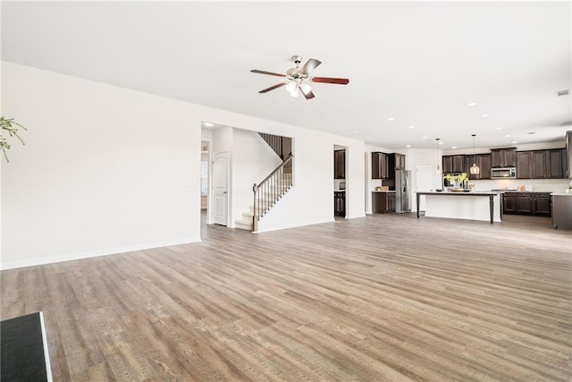 unfurnished living room with ceiling fan and hardwood / wood-style floors