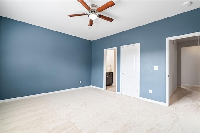 unfurnished bedroom with ensuite bathroom, light carpet, and ceiling fan