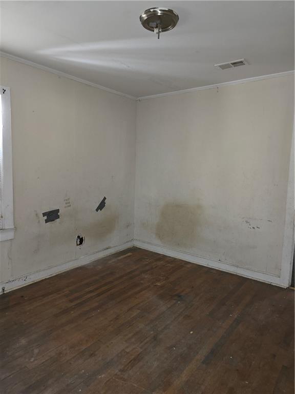 unfurnished room featuring ornamental molding, hardwood / wood-style flooring, and baseboards