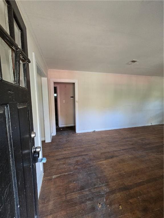 unfurnished room featuring dark wood-type flooring and baseboards