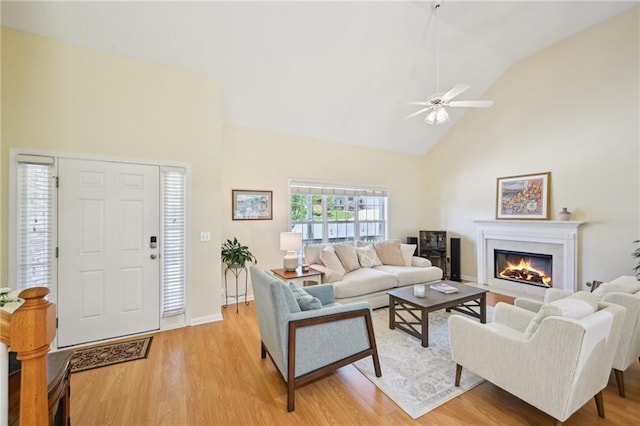3705 Tate Pl, Austell, GA 30106 - living area featuring high vaulted ceiling, light wood-style flooring, a glass covered fireplace, ceiling fan, and baseboards