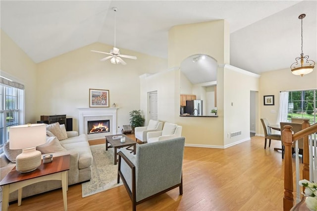 3705 Tate Pl, Austell, GA 30106 - living room with high vaulted ceiling, ceiling fan, a warm lit fireplace, light wood-style flooring, and baseboards