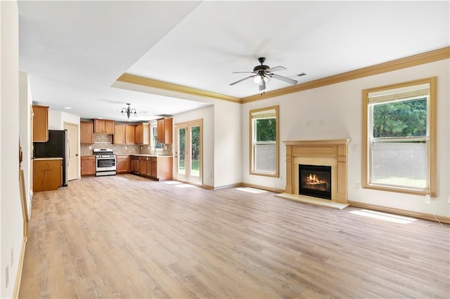 1492 Station Ridge Ct, Lawrenceville, GA 30045 - unfurnished living room featuring healthy amount of natural light, light wood-style floors, a lit fireplace, and crown molding