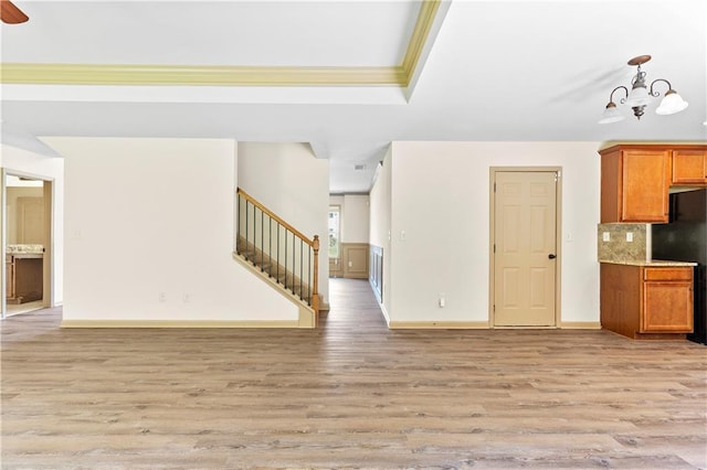 1492 Station Ridge Ct, Lawrenceville, GA 30045 - unfurnished living room with light wood-style flooring, stairway, a raised ceiling, a chandelier, and crown molding