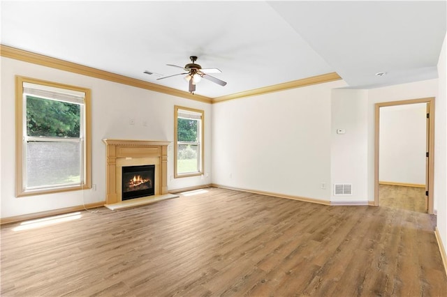 1492 Station Ridge Ct, Lawrenceville, GA 30045 - unfurnished living room with ceiling fan, plenty of natural light, ornamental molding, wood finished floors, and a glass covered fireplace
