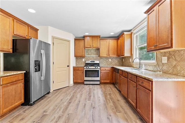 1492 Station Ridge Ct, Lawrenceville, GA 30045 - kitchen with stainless steel appliances, light wood-style floors, brown cabinetry, light stone counters, and recessed lighting
